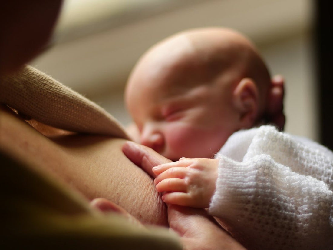Mano de bebé tomando el dedo de su mamá